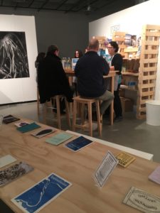 A group of people sitting at a table in the exhibit.