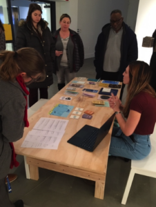 A group of people surrounding an educational tabling event.