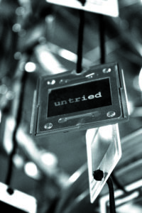 Black and white photo of a metal hanging plate labeled "untried"