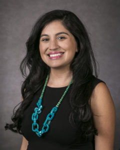 Portrait photograph of Mia Lopeza in a black top with a turquoise blue necklace.