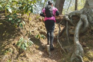 Photo of man hiking with pink shirt and black backpack