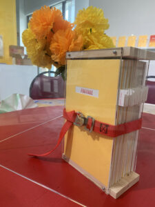 Image of a yellow bound book and vase of flowers