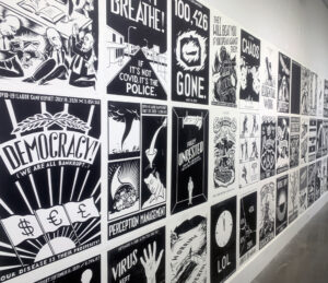 Grid of black and white postered install on the white exhibit wall.